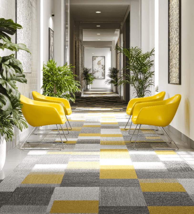 Yellow and grey carpet tile laid in a bright corridor with lounge seating